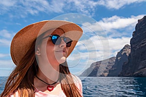 Los Gigantes - Close up view on tourist woman with beach hat near the cliffs of Los Gigantes, Tenerife, Spain.