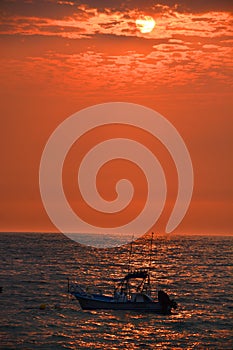 Los Muertos beach against sunset sky.