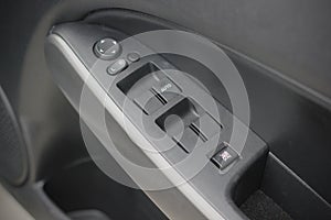 Ð¡lose-up of the car black interior: the side door buttons: window adjustment buttons, door lock and other buttons.
