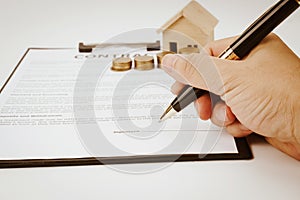 Lose up of man signing rental agreement or sale purchase contrac.Buying and renting new home concept.