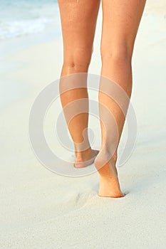 Ð¡lose up of woman leg on the beach. Woman  feet walking on the sand. Foot female.