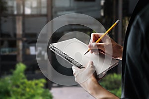 Lose up of woman`s hand writingis taking notes while standing over