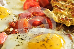 Ð¡lose up of yolk from fried eggs and sliced tomatoes with onion for breakfast without plate
