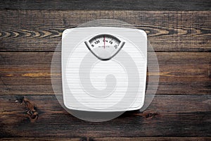 Lose weight concept. Scale on dark wooden background top view