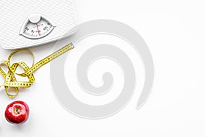 Lose weight concept. Scale and measuring tape on white background top view copy space