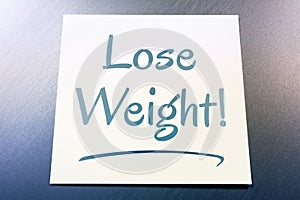 Lose Weight Reminder On Paper Lying On Brushed Aluminum Of Fridge