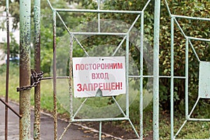 Ð¡losed gate with inscription `No entry for unauthorised people` on Russian. Restricted area or prohibited zone concept