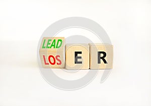 Loser or leader symbol. Businessman turns wooden cubes and changes the word Loser to Leader. Beautiful white table white