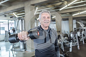 Losing weight and gainiong strength by a dumbell training performed by older man in the fitness center