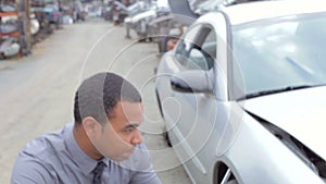 Loss Adjuster Inspecting Car Wreck Using Digital Tablet