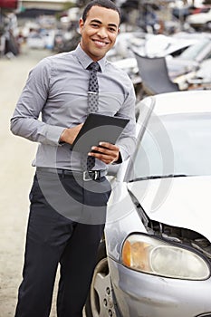 Loss Adjuster Using Digital Tablet In Car Wreck Inspection