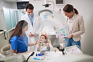 Loss baby teeth. dentist examining his girl patient in dentistÃ¢â¬â¢s photo