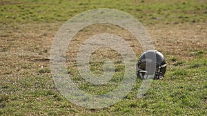 Loss of interest in sports, forgotten football helmet lying on stadium pitch