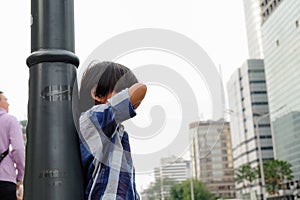 Lost Asian Child Seems Crying Lean Back His Body to a City Lamp Pole