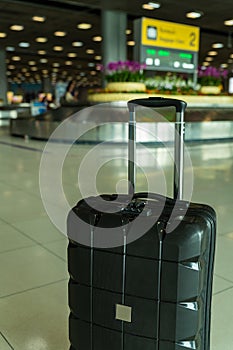 Lost black hardshell carry-on roller luggage left unattended at the baggage reclaim area at airport