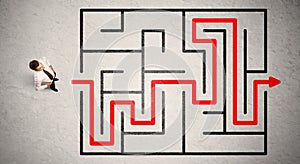 Lost businessman found the way in maze with red arrow