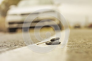 Lost car keys lying on the roadway, on a blurred background with bokeh effect