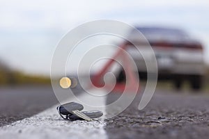 Lost car keys lying on the roadway, on a blurred background with bokeh effect