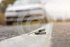 Lost car keys lying on the roadway, on a blurred background with bokeh effect