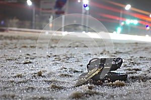 Lost car keys on the road powdered with the first snow at night. on blurred background