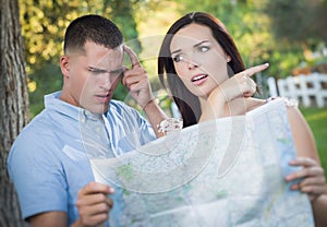 Lost and Confused Mixed Race Couple Looking Over Map Outside