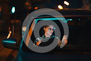 Lost female driver using mobile phone while driving at night.