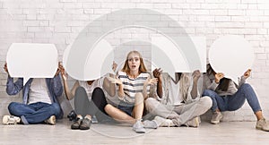 Lost girl sitting among friends covering faces with speech bubbles