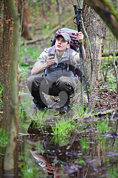 Lost hiker in forest with mobile satelite navigation device