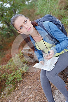 Lost hiker girl with map on forest road