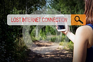 LOST INTERNET CONNECTION concept. A woman with a cell phone in the woods