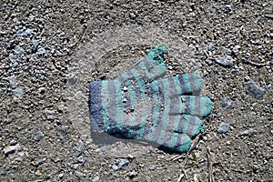 Lost knitted child`s glove on the ground