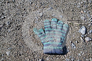 Lost knitted child`s glove on the ground