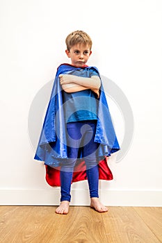 Lost little superhero child with arms folded thinking about sadness photo