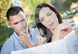 Lost Mixed Race Couple Looking Over Map Outside