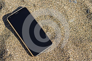 The lost phone is located on the sand