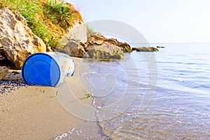 Lost plastic blue barrel on sandy beach