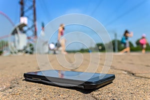 Lost smartphone lies on the road in a public park