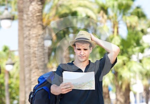 Lost tourist with bag holding map