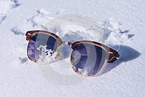 Lost tourist women`s sunglasses in the snow in winter