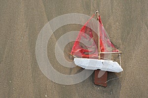 Lost toy boat washed up on beach from above