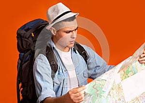 Lost traveler with backpack looking at city map