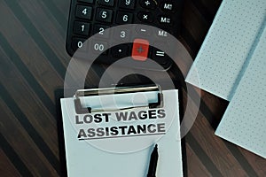 Lost Wages Assistance write on a paperwork isolated on Wooden Table. Business or Finance concept