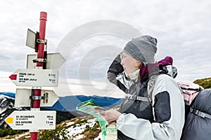 Lost woman look at pointer in mountains