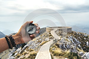 Lost woman on the mountain, orienting herself with a compass. Find a solution