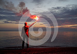 Losted Man on a Beach Holding Emergency Fire photo