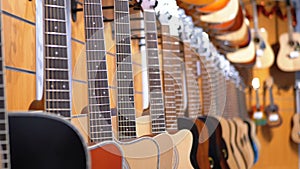 Lot of acoustic guitars hanging in a music store. Shop musical instruments.