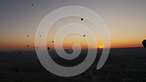 A lot of air balloons are flying in the sky in Cappadocia at sunrise