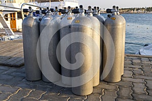 A lot of aluminum scuba diving oxygen tanks standing .