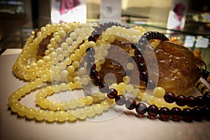 A lot of Baltic amber white beads lie on a piece amber.