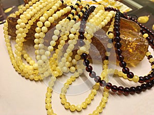 A lot of Baltic amber white beads lie on a piece amber.